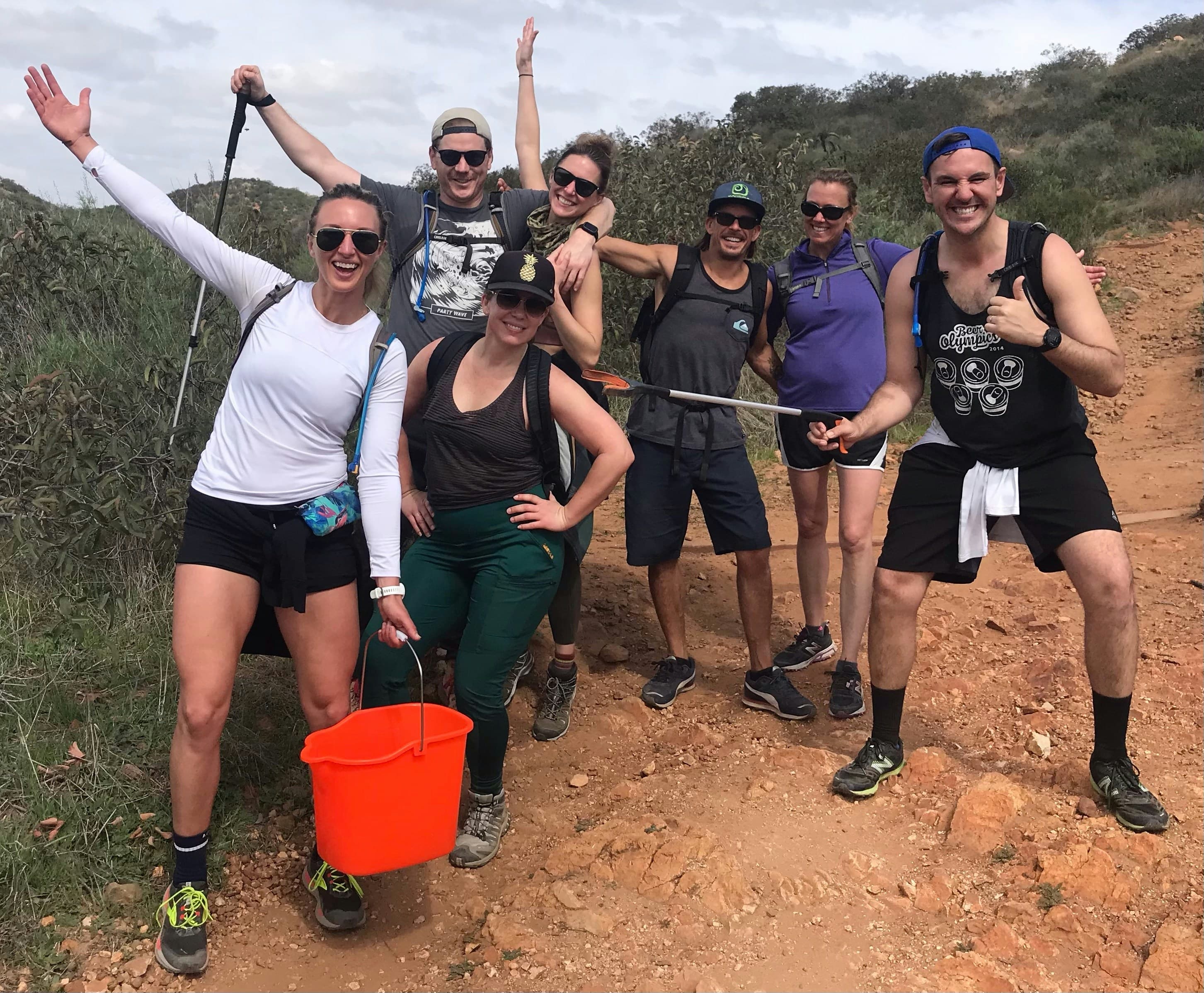 Group of volunteers with cleanup supplies on hiking trail during community cleanup event
